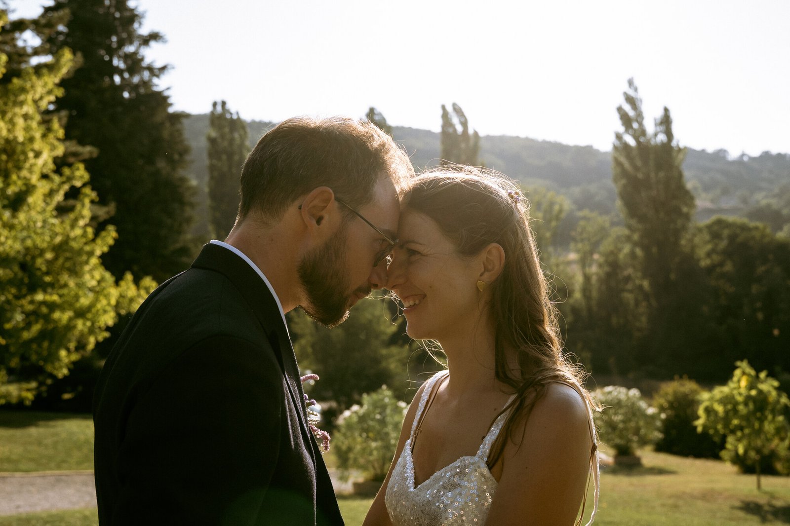 Le marié dévoilant la mariée sous les frondaisons