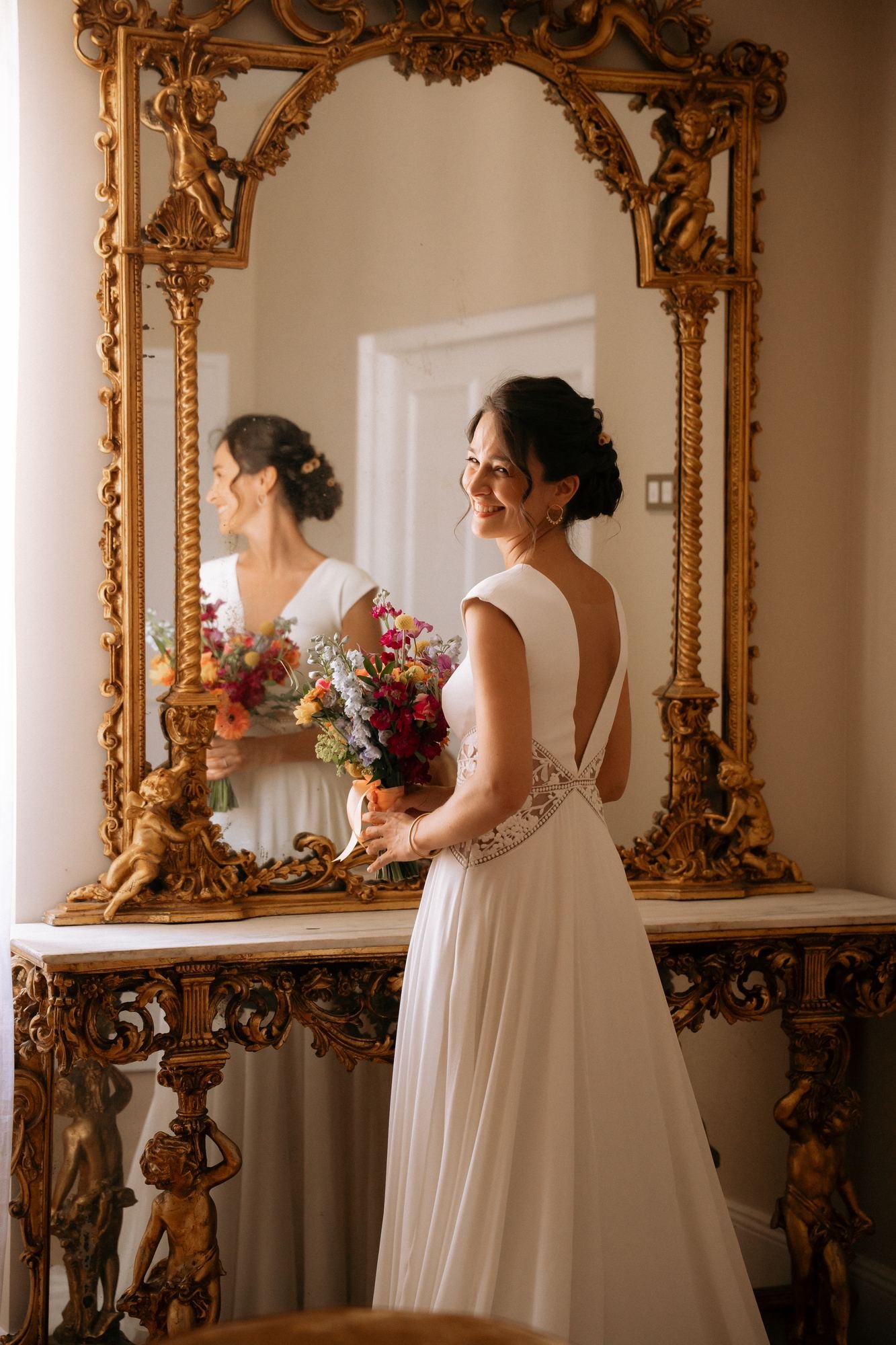 Mariée souriante devant un miroir doré