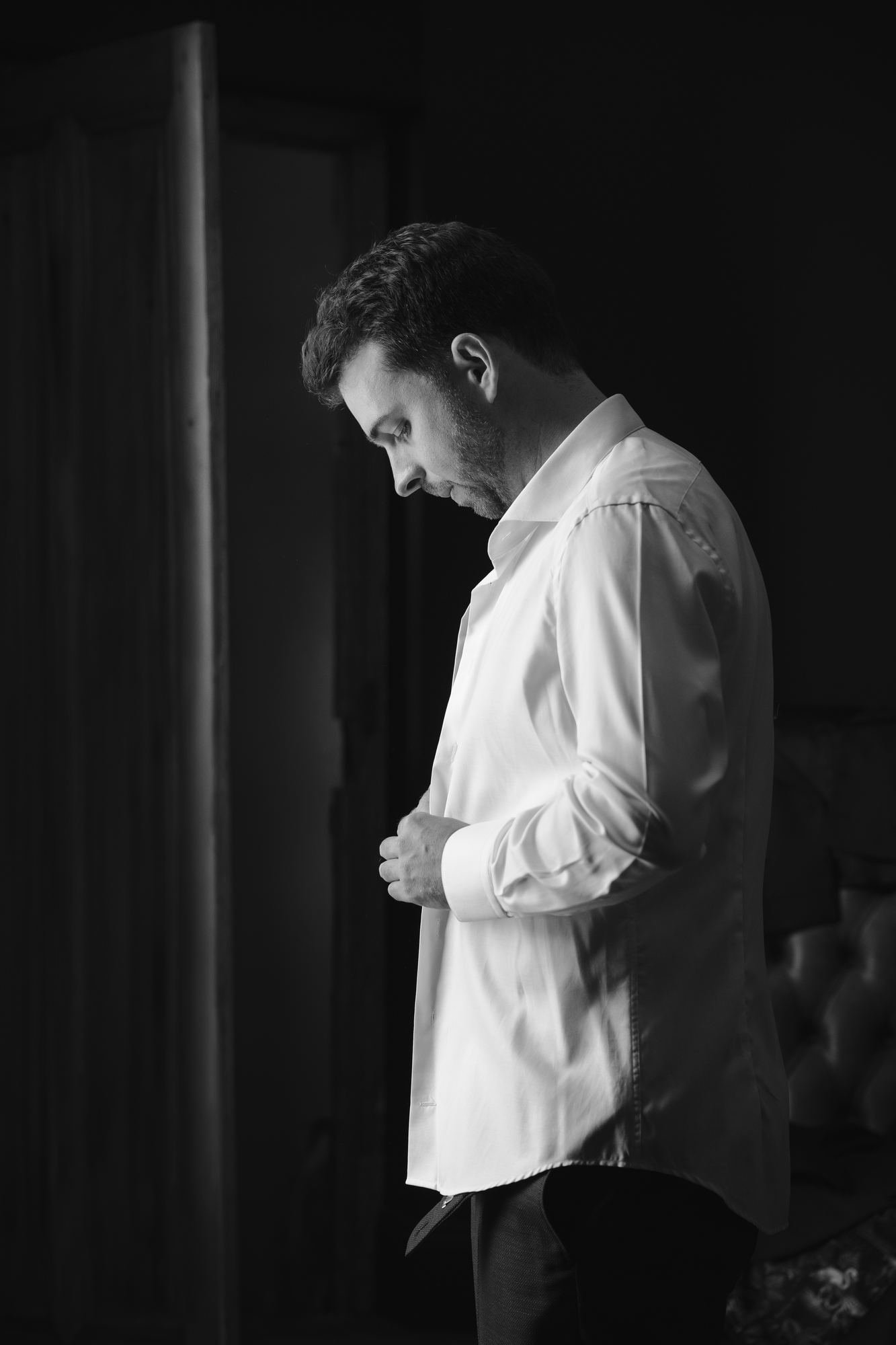 Le marié boutonnant sa chemise
