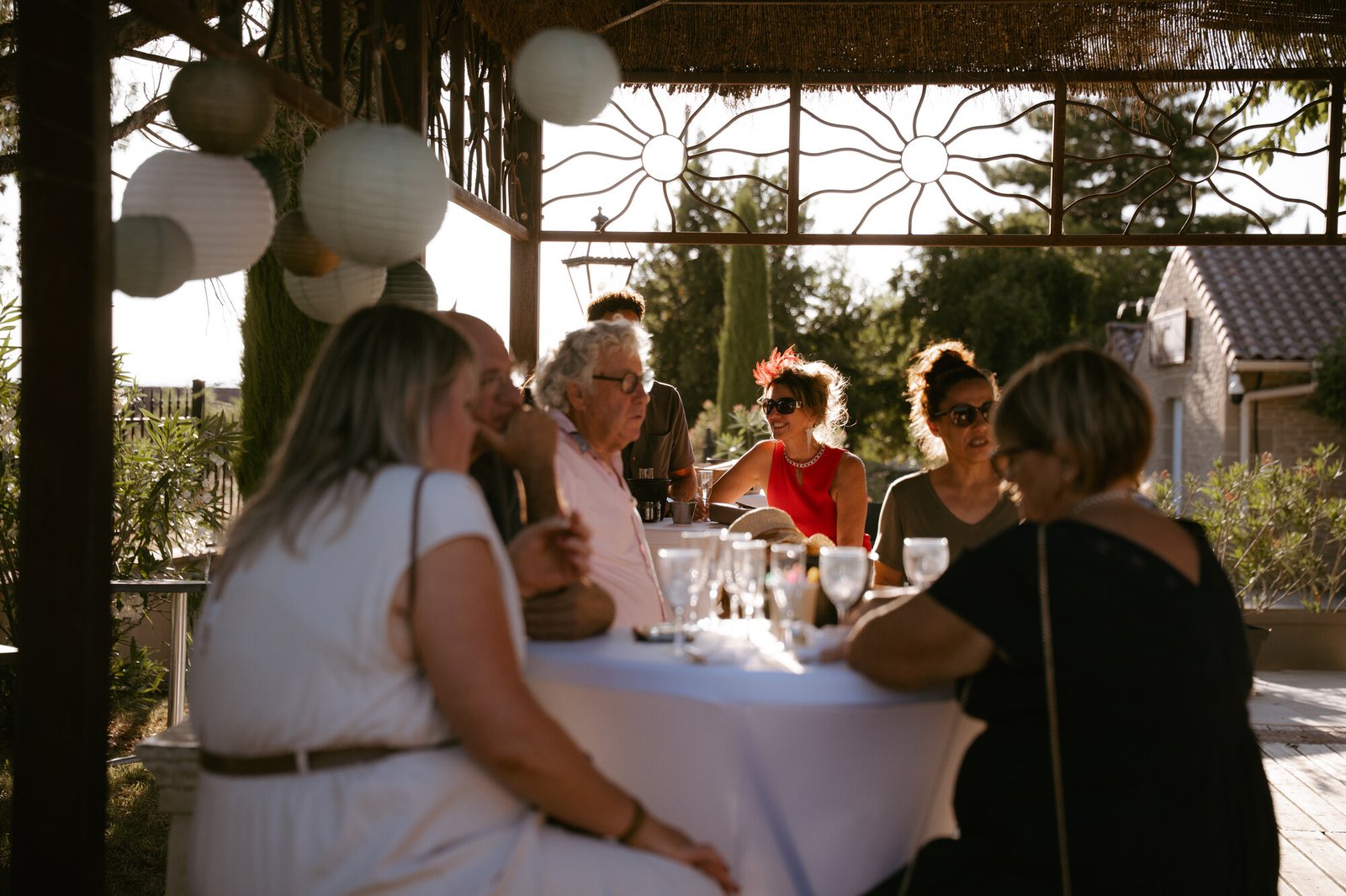 Invités attablés sous la tonnelle au coucher du soleil